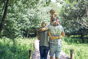 Family with little girl walking on a wooden walkway in the countryside - DAPF00843