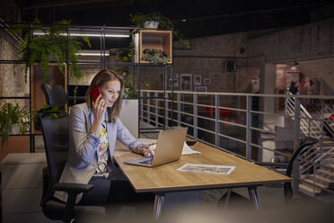 Geschäftsfrau, die in einem modernen Büro arbeitet, mit Laptop und Telefon - WESTF23778
