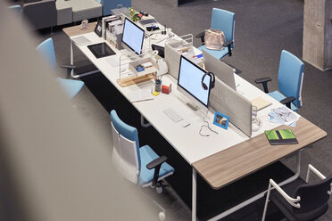 Desk in modern office with blank monitors - WESTF23787