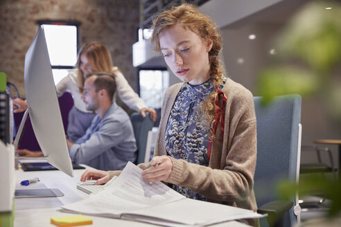 Junge Frau arbeitet in einem modernen, kreativen Büro und benutzt einen Laptop - WESTF23808