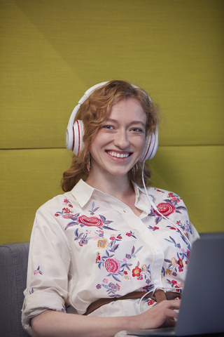 Young woman working in modern creative office, wearing headphones stock photo