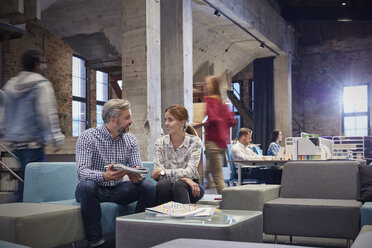 Business people having a informal meeting in communications pit - WESTF23862