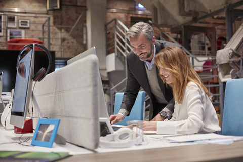 Businessman and woman working together in modern office stock photo