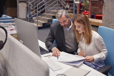 Businessman and woman working together in modern office - WESTF23875