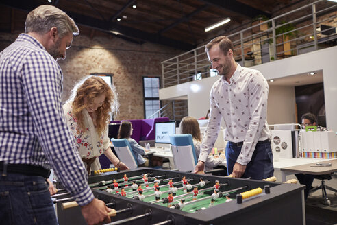 Geschäftsleute im Büro, die eine Pause machen und Tischfußball spielen - WESTF23901