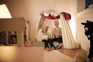 Porträt von zwei glücklichen Mädchen mit Tablet im Kinderzimmer - MOEF00523
