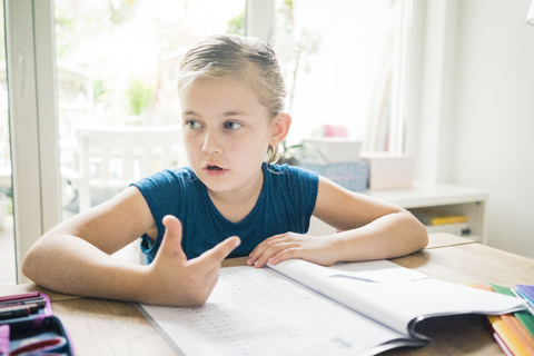 Girl doing homework at table stock photo