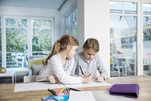 Zwei Mädchen machen zusammen am Tisch Hausaufgaben - MOEF00546