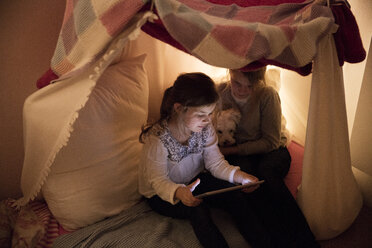 Zwei Mädchen mit Hund und Tablet im Kinderzimmer - MOEF00552