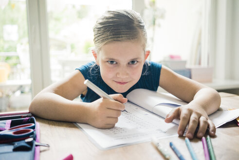 Porträt eines Mädchens, das am Tisch Hausaufgaben macht - MOEF00557