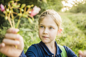 Porträt eines Mädchens mit einer wilden Blume in der Natur - MOEF00567