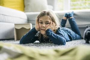 Porträt eines Mädchens, das mit einem Hasen im Wohnzimmer liegt - MOEF00579