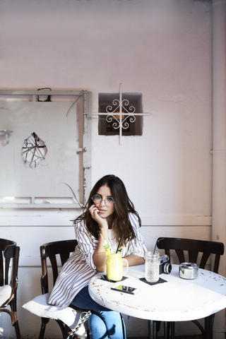 Portrait of young woman sitting in a coffee shop stock photo