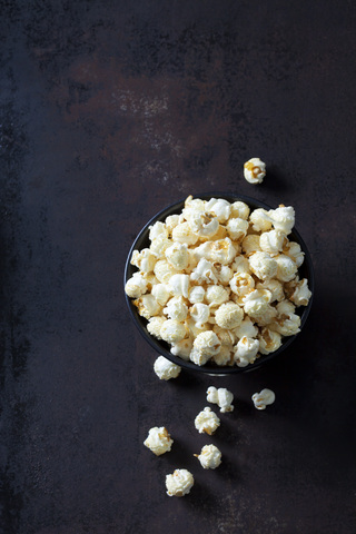 Schale mit Popcorn auf rostigem Hintergrund, lizenzfreies Stockfoto