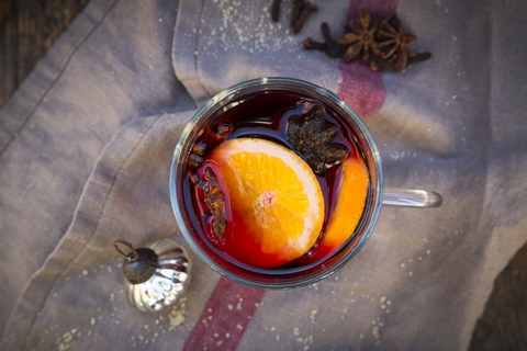 Glass of mulled wine with orange slices, cinnamon sticks, star anise and cloves at Christmas time stock photo