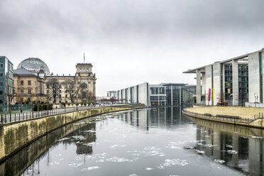 Deutschland, Berlin, Berlin-Mitte, Regierungsviertel, Reichstag und Paul-Loebe-Gebäude mit Spree im Vordergrund im Winter - PUF00993