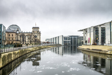 Germany, Berlin, Berlin-Mitte, Government district, Reichstag and Paul-Loebe-Building with Spree River in the foreground in winter - PUF00993