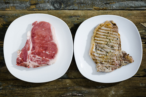 Row and roasted beefsteak on plate stock photo