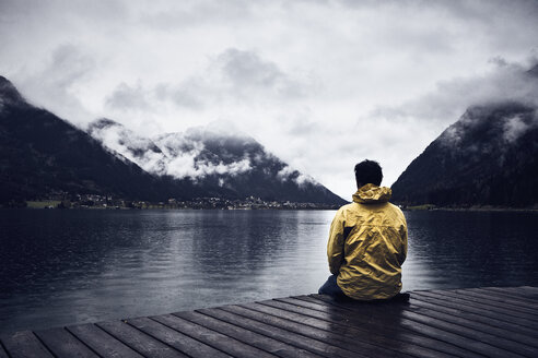 Austria, Tyrol, Lake Achen, man sitting on boardwalk - RBF06229