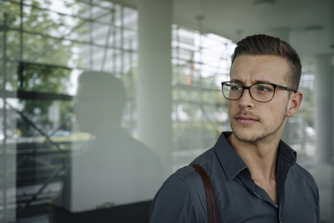 Portrait of pensive young businessman wearing glasses stock photo