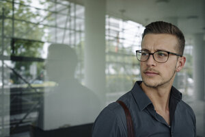 Porträt eines nachdenklichen jungen Geschäftsmannes mit Brille - KNSF03248