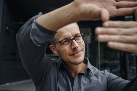 Portrait of smiling businessman making finger frame stock photo