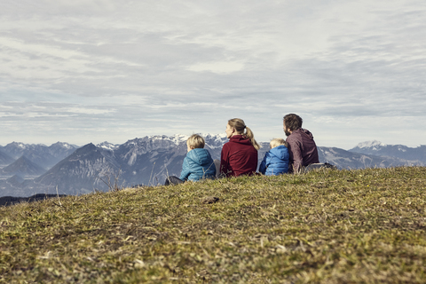 Italy, South Tyrol, Geissler group, family hiking, sitting on meadow stock photo