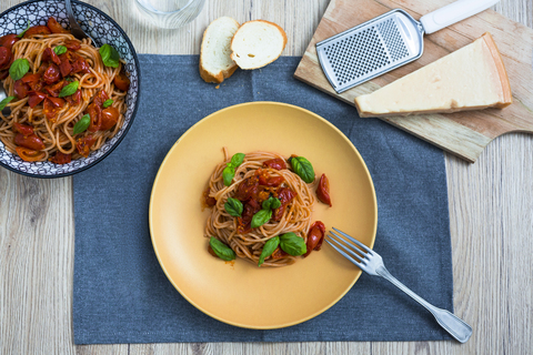 Spaghetti with cherry tomatoes and basil on a plate stock photo