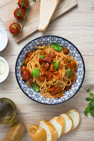 Spaghetti with cherry tomatoes and basil in a bowl stock photo