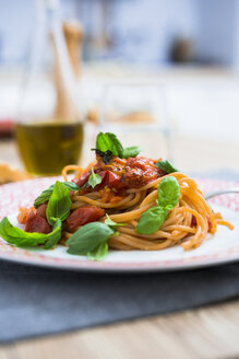 Spaghetti mit Kirschtomaten und Basilikum auf einem Teller - GIOF03716