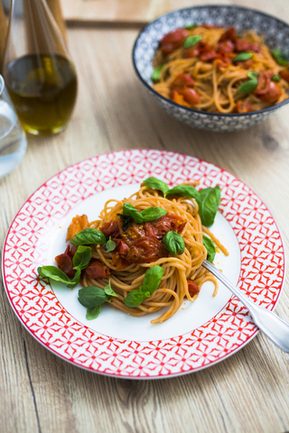 Spaghetti mit Kirschtomaten und Basilikum auf einem Teller, lizenzfreies Stockfoto