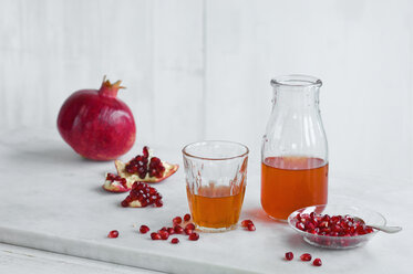 Glas und Flasche mit Granatapfelsaft, ganzem Granatapfel und Granatapfelkernen - ASF06136