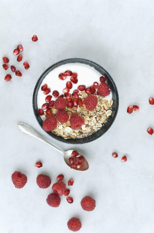 Bowl of fruit muesli with raspberries and pomegranate seed stock photo