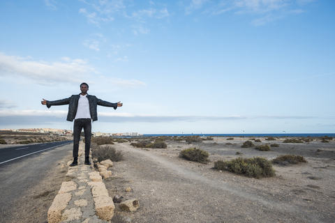 Spanien, Teneriffa, junger Mann an der Wand stehend, lizenzfreies Stockfoto