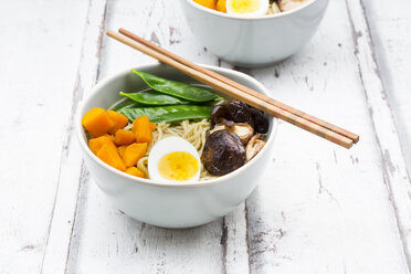 Ramen with noodles, egg, hokkaido pumpkin, mung sprout, shitake mushroom in bowl, chopsticks - LVF06550