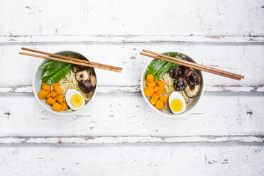Ramen with noodles, egg, hokkaido pumpkin, mung sprout, shitake mushroom in bowl, chopsticks - LVF06551