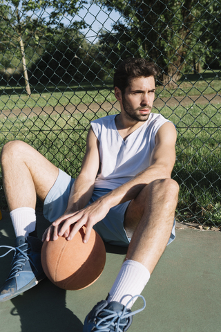 Basketball player sitting on the ground stock photo