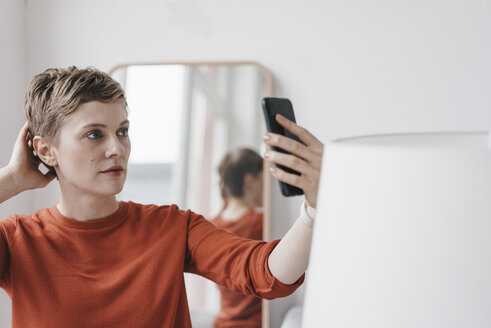 Portrait of woman holding cell phone - KNSF03264