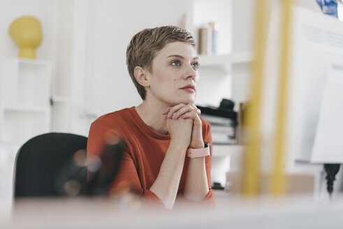 Frau am Schreibtisch im Büro schaut auf den Computerbildschirm - KNSF03274