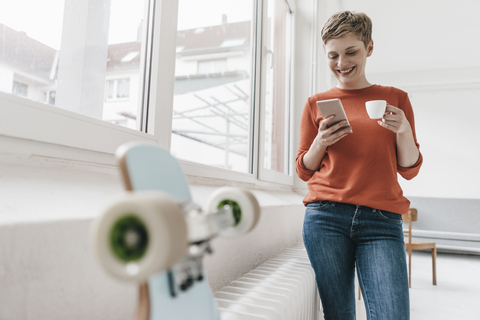 Smiling woman with cell phone and espresso cup stock photo
