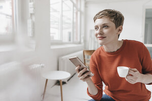 Lächelnde Frau mit Mobiltelefon und Espressotasse - KNSF03278