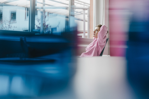 Pensive woman sitting at desk looking out of window stock photo