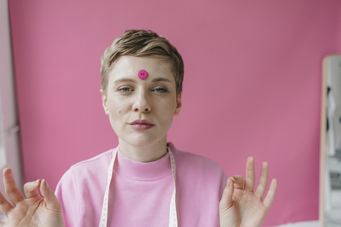 Portrait of tailoress with pink button at her forehead stock photo