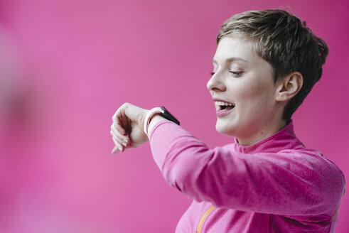 Frau in rosa Sportkleidung trägt Smartwatch - KNSF03317