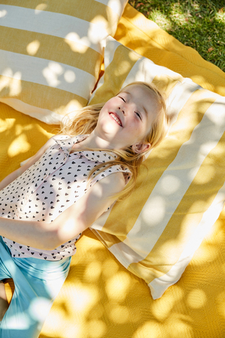 Happy girl lying on a blanket stock photo