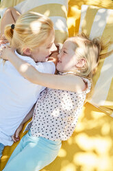 Happy girl with mother lying on a blanket - SRYF00597