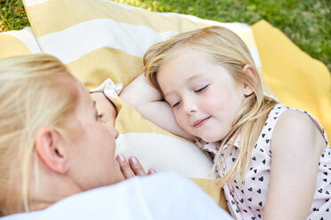 Smiling girl and mother lying on a blanket - SRYF00601