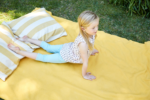 Mädchen übt Yoga auf einer Decke, lizenzfreies Stockfoto