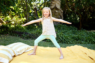 Girl practicing yoga on a blanket - SRYF00606