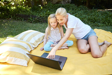 Mädchen und Mutter benutzen Laptop auf einer Decke - SRYF00607